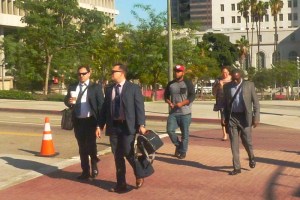 couple of attorney in suits cross the street along with 2 other males leaving work