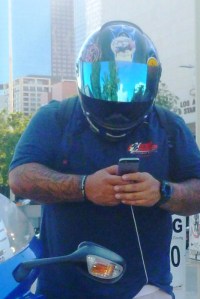 guy on smart phone checking data before he taked to street on his motorcycle