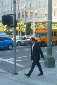 man in suit walks in downtown Los Angeles bewteen court buildings