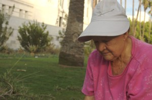 older lady preping for dinner in garden for cats