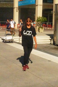 teen walking thru theater court area flashed a peace sign with a bih smile.of theater 