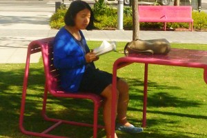 mature woman reads papers in downtown LA park