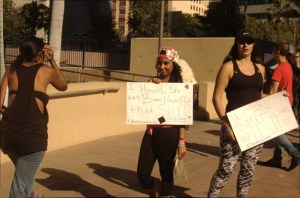 2 hispanic women in 20 twentys hold signs for slutwalk LA photo