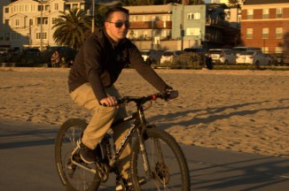 man rides his bike at the golden hour Santa Monica Beach CA