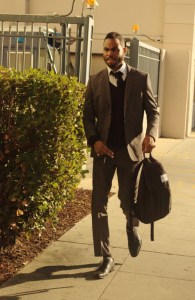 africian amercian male in suit walks to garage from city hall