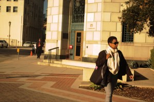 african american woman with sunglasses walks near city hall