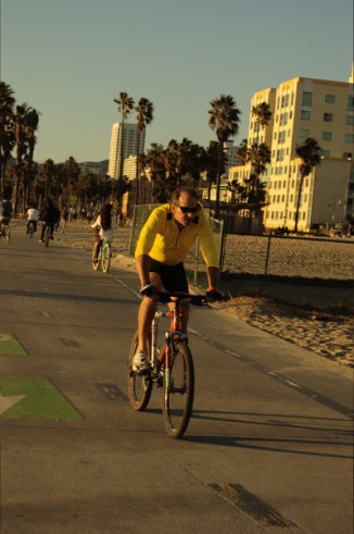 middle aged white man in yellow shirt rides bike Santa Monica CA