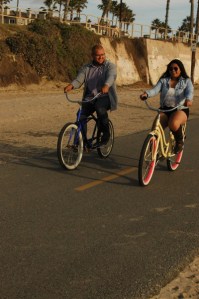 colorful photo of young couple riding bikes and laughing