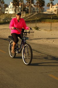 atrractive woman in pink smile riding a bike