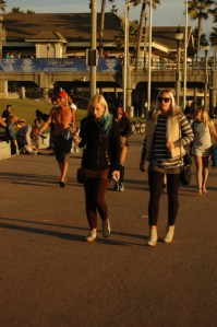 blondes walk along beach with shopping bag