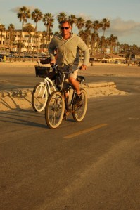 male rides a bike with sunglasses & smile