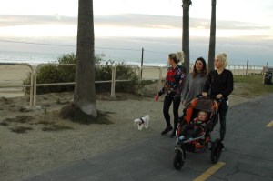 baby smiles while mom & 3 girls walk along huntinton beach