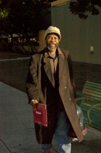 attractive smiling African American man walks with colorful hat and winter coat