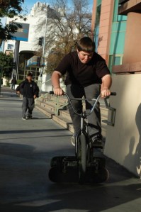 teen jumps bike over skateboards
