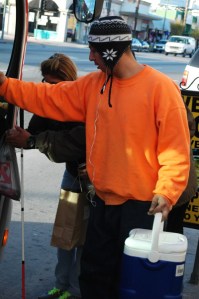 colorful guy assists someone getting off bus