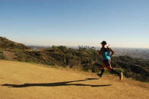 Hispanic male jogs on scenic trail in Griffith Park, LA, CA