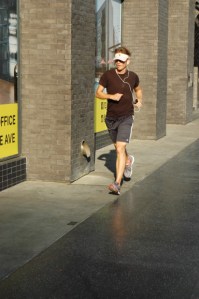 20 something man jogs on hollywood bvld