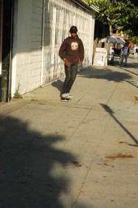 young african amercian skatesboards on Hollywood Blvd