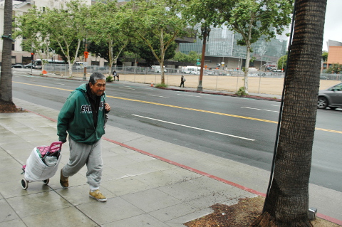 Asain man walks with food type wheel basket