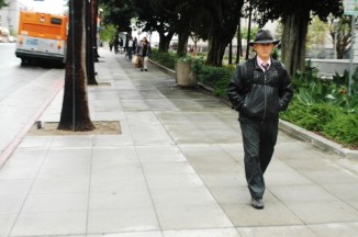 man in suit with tie and leather hat walks near City Hall Los Angeles CA 4/8/18
