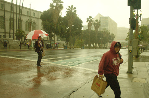 Hispanic man crossesstreet in rain 4/8/16 Los Angeles CA