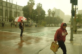 Hispanic man crossesstreet in rain 4/8/16 Los Angeles CA