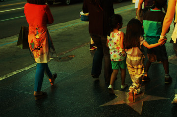 fmaily with 2 young girls walk down Hollywood
