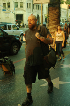 bald guy with bread and many tattoos