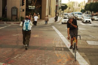 man on bike and others cross downtown St