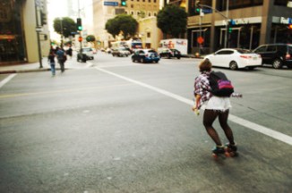 attractive female on roller skates rolls down Flower St