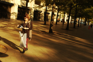 woman reads somethig while walking