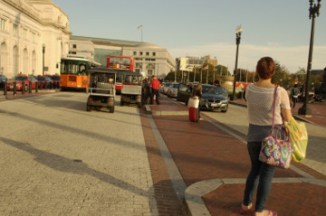female waits for ride outside Union Station